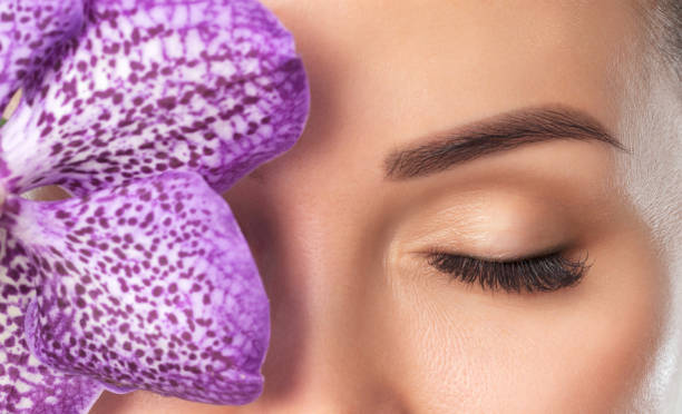 Beautiful woman with long eyelashes, beautiful make-up and thick eyebrows. Professional makeup and cosmetology skin care.